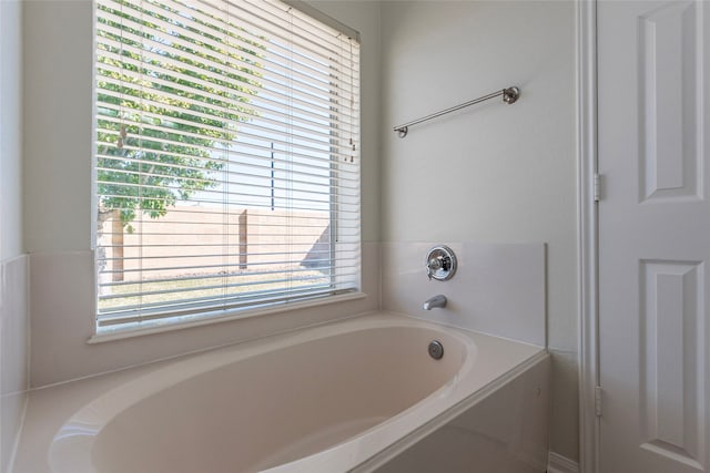 bathroom with plenty of natural light and a tub