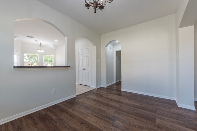 unfurnished room with hardwood / wood-style floors and a chandelier