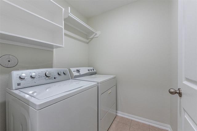 laundry room with washing machine and dryer and light tile patterned flooring