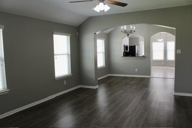 spare room featuring vaulted ceiling, plenty of natural light, and dark hardwood / wood-style floors