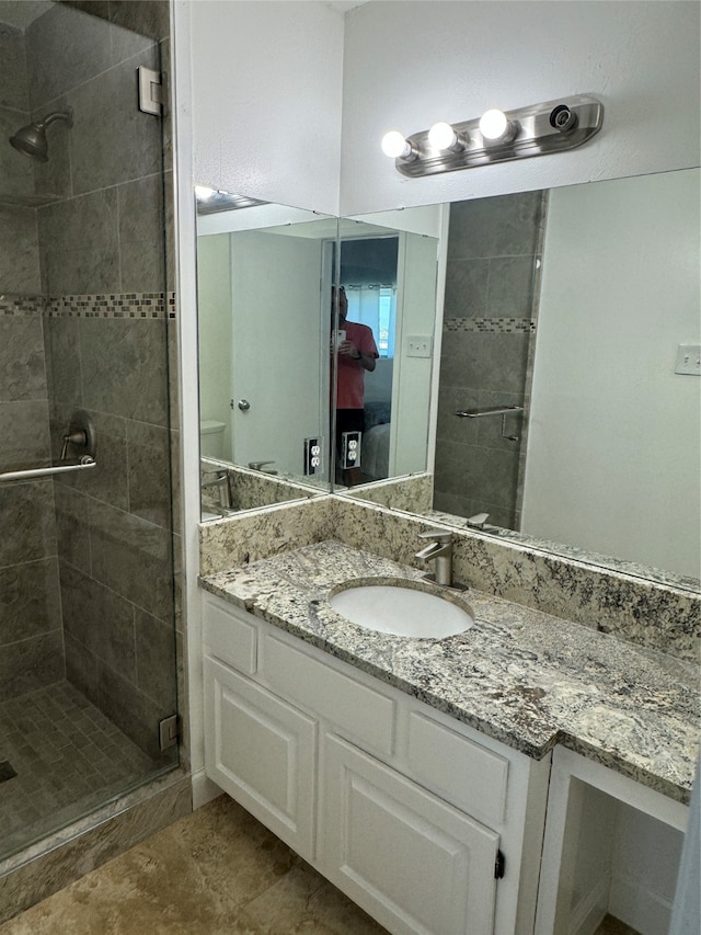 bathroom with vanity and a shower with shower door