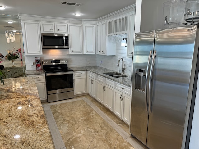 kitchen featuring sink, white cabinetry, stainless steel appliances, backsplash, and light stone countertops