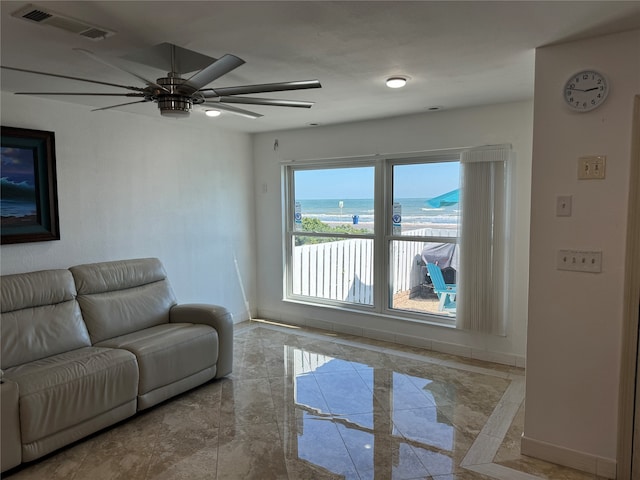 living room featuring ceiling fan and a water view