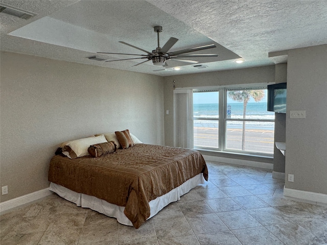 bedroom featuring ceiling fan and a textured ceiling