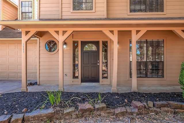 entrance to property featuring a garage and a porch