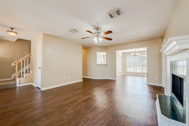 unfurnished living room with dark hardwood / wood-style floors and ceiling fan with notable chandelier