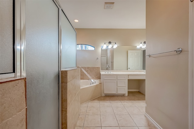 bathroom featuring vanity, tiled tub, and tile patterned flooring