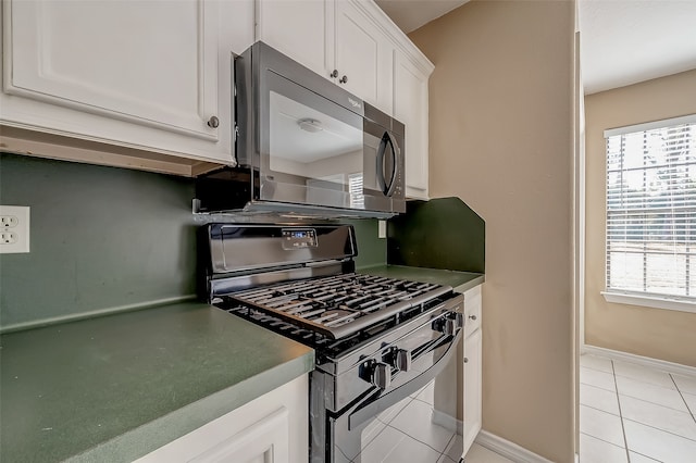 kitchen featuring white cabinetry, stainless steel appliances, and light tile patterned floors