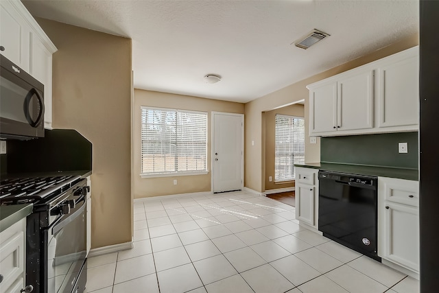 kitchen with a textured ceiling, black appliances, light tile patterned floors, and white cabinets