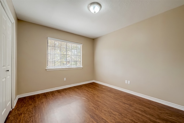 spare room with dark wood-type flooring