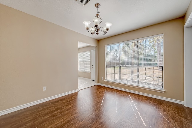 unfurnished dining area with light hardwood / wood-style flooring and a chandelier