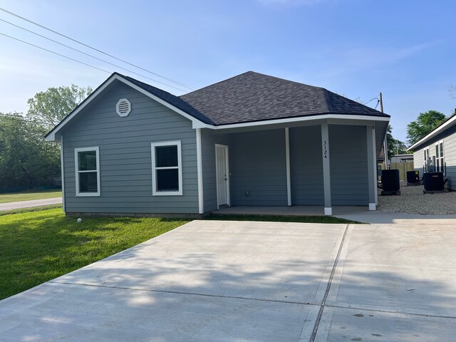 view of front of property featuring a carport, a front lawn, and central air condition unit