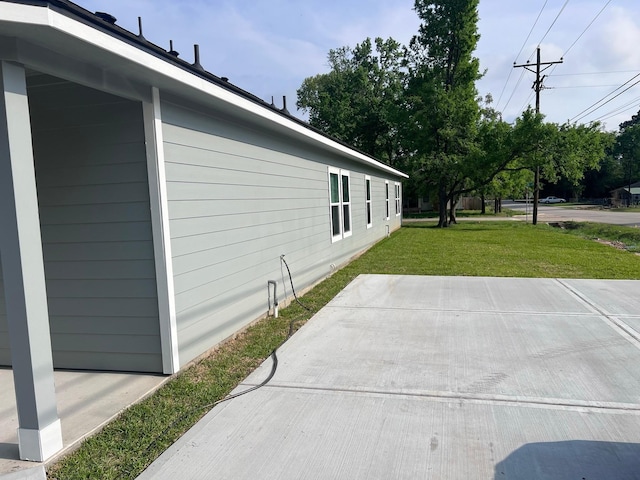 view of home's exterior with a patio area and a yard