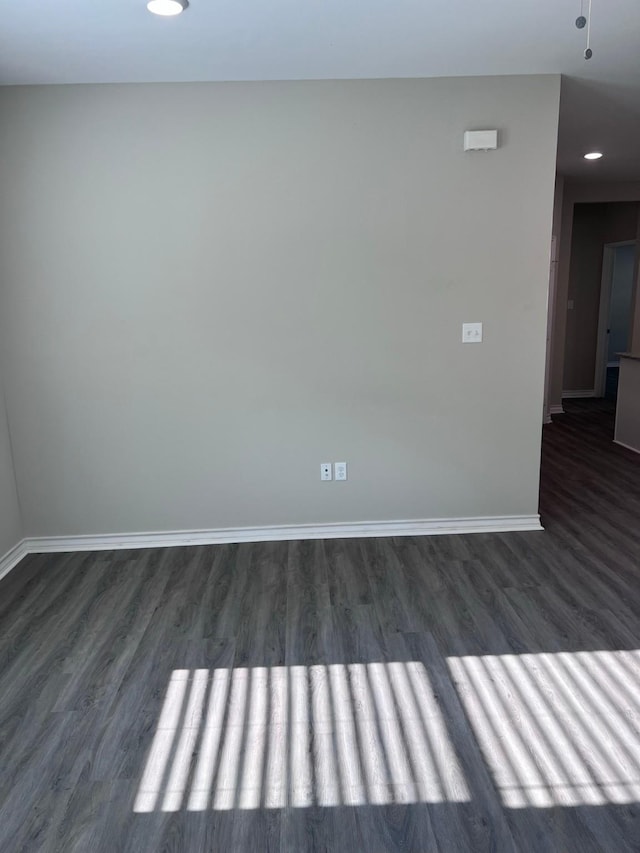 spare room featuring baseboards, recessed lighting, and dark wood-style floors