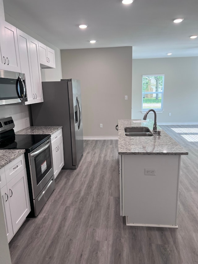 kitchen featuring white cabinetry, stainless steel appliances, a kitchen island with sink, dark hardwood / wood-style floors, and sink