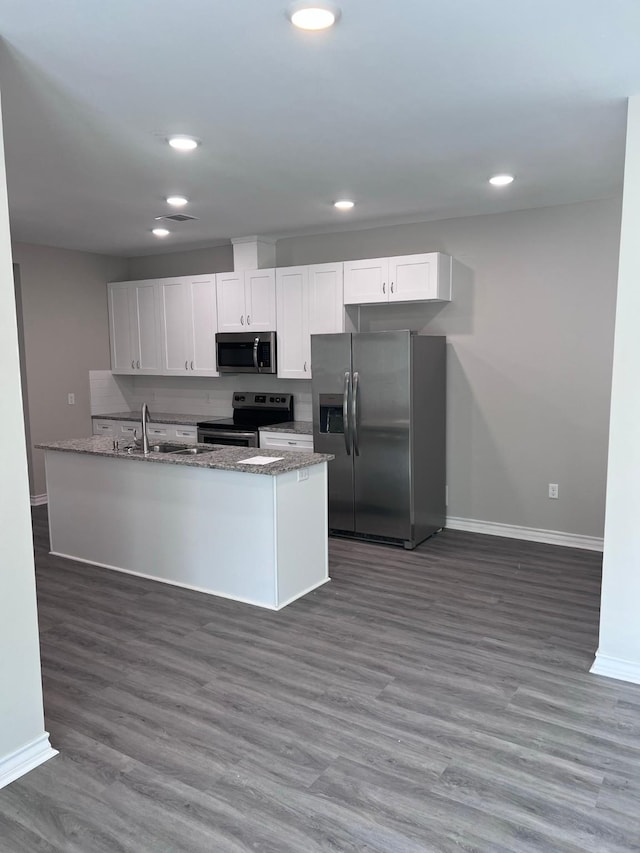 kitchen with wood finished floors, baseboards, stone countertops, white cabinetry, and stainless steel appliances