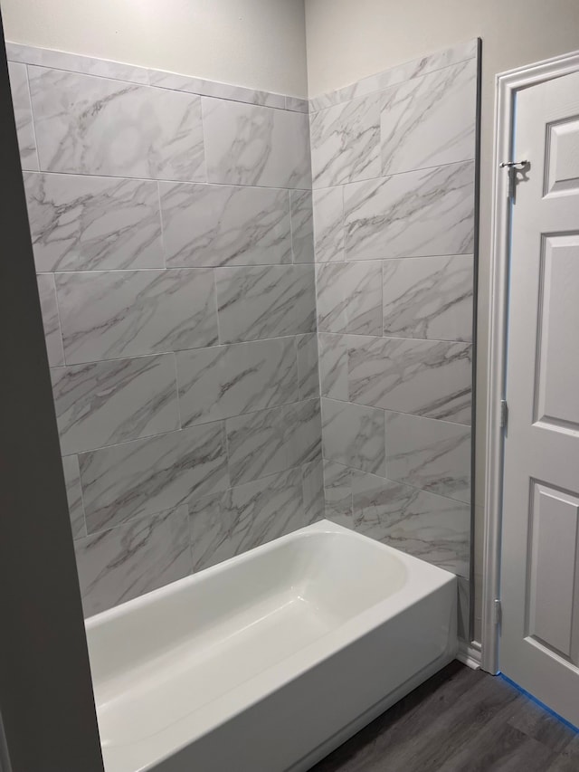 bathroom featuring tiled shower / bath and hardwood / wood-style flooring