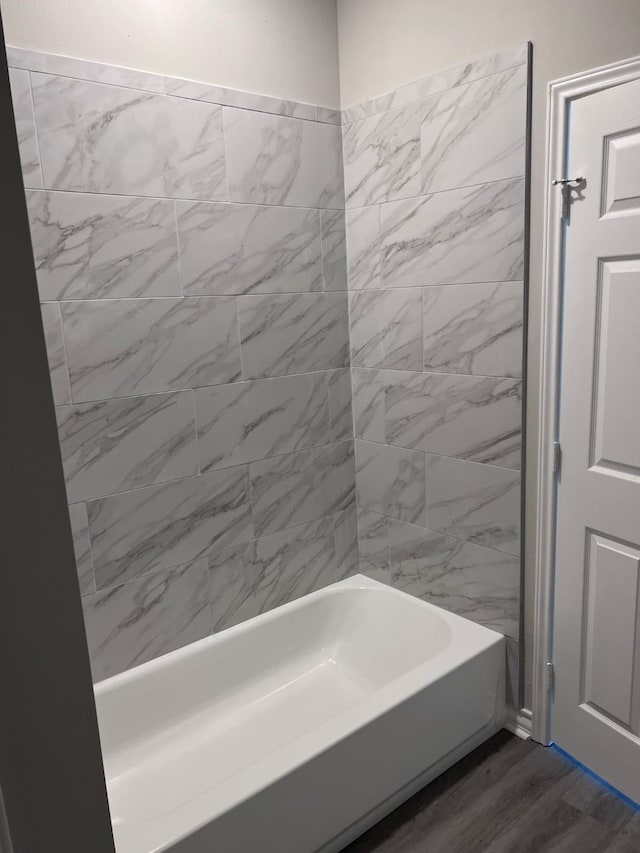 bathroom with wood finished floors and bathing tub / shower combination