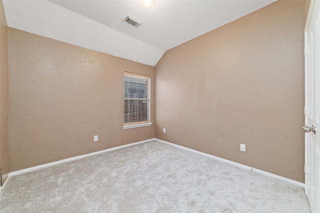 carpeted empty room featuring lofted ceiling