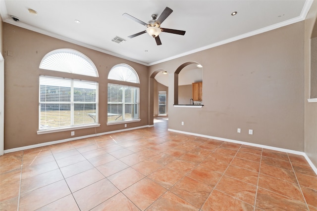 unfurnished living room with ceiling fan, ornamental molding, and a healthy amount of sunlight