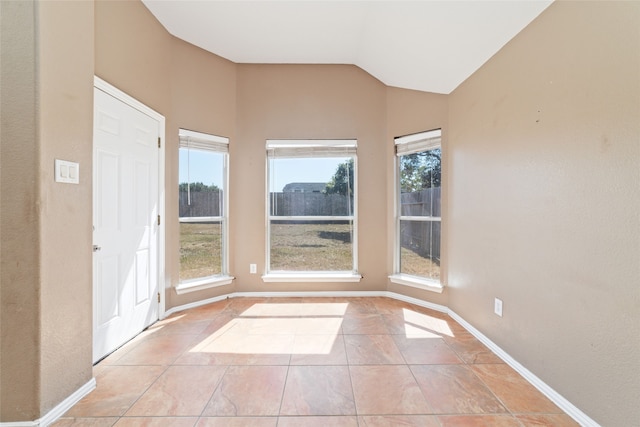 tiled spare room with lofted ceiling