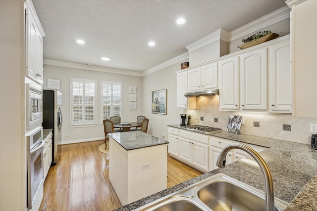 kitchen featuring light hardwood / wood-style flooring, white cabinets, stainless steel appliances, and a kitchen island