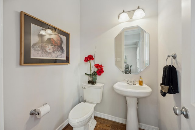 bathroom with hardwood / wood-style flooring, toilet, and sink