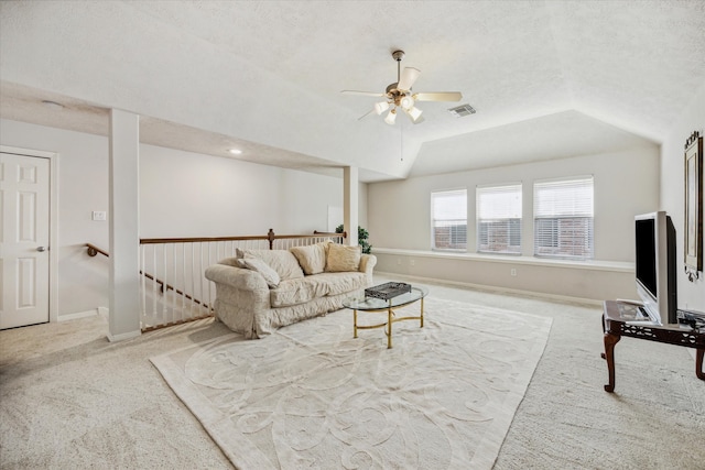 carpeted living room with vaulted ceiling, ceiling fan, and a textured ceiling