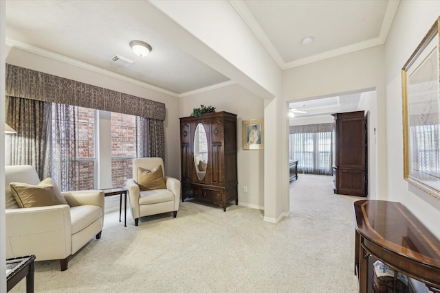 sitting room with light carpet, a wealth of natural light, and ornamental molding