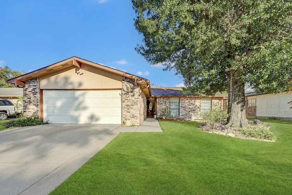 ranch-style house featuring a garage and a front yard