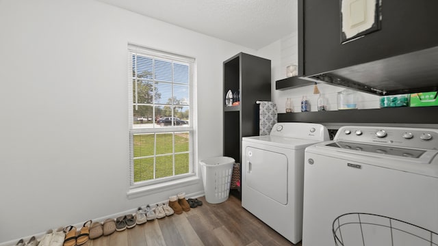 laundry area featuring dark wood-type flooring, a textured ceiling, and washing machine and clothes dryer