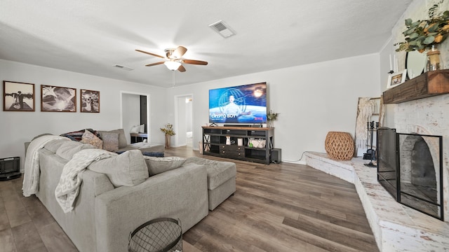 living room featuring ceiling fan, crown molding, a textured ceiling, and hardwood / wood-style floors