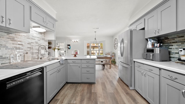 kitchen featuring light hardwood / wood-style floors, tasteful backsplash, dishwasher, and gray cabinets