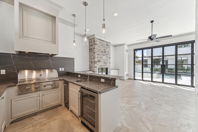 kitchen featuring ceiling fan, decorative backsplash, kitchen peninsula, pendant lighting, and wine cooler