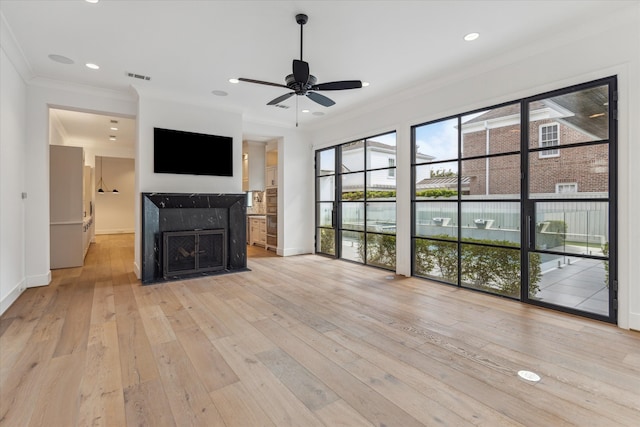 unfurnished living room featuring light wood-type flooring, crown molding, and ceiling fan