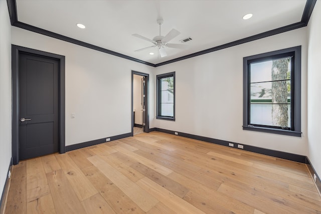 spare room featuring ceiling fan, light wood-type flooring, plenty of natural light, and ornamental molding