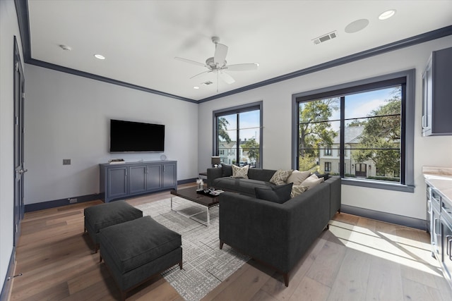 unfurnished living room featuring ornamental molding, light wood-type flooring, and ceiling fan