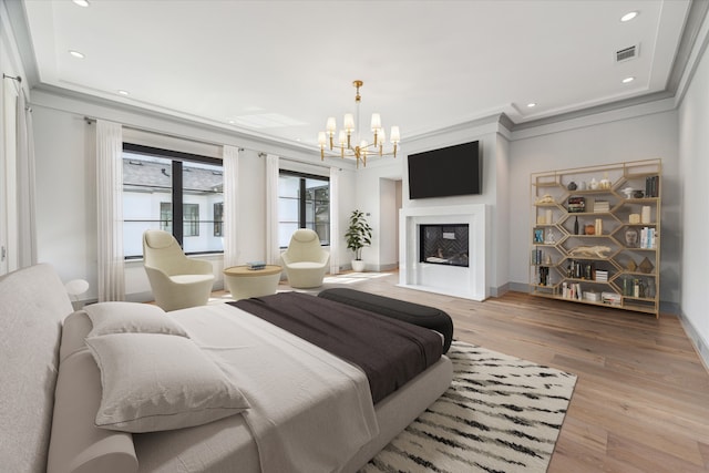 bedroom with wood-type flooring, ornamental molding, and a chandelier