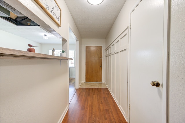 hallway featuring wood-type flooring and a textured ceiling