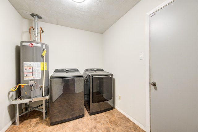 clothes washing area with a textured ceiling, washing machine and clothes dryer, and gas water heater