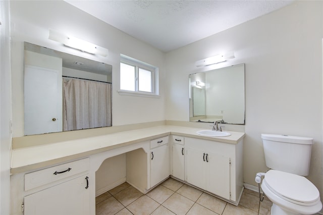 bathroom with vanity, a textured ceiling, toilet, and tile patterned floors