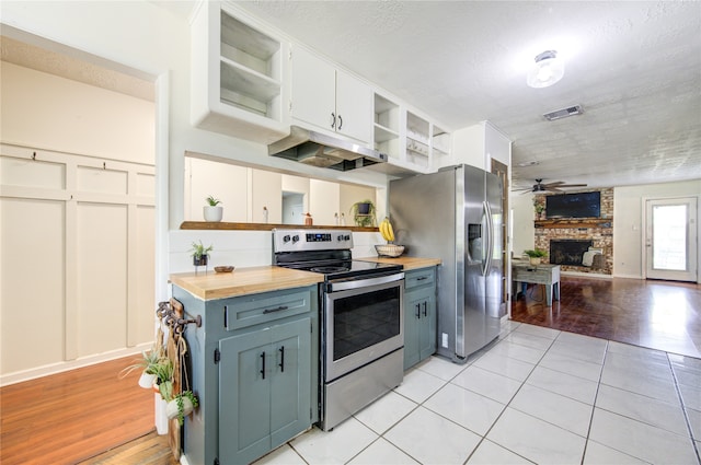 kitchen featuring appliances with stainless steel finishes, light hardwood / wood-style flooring, white cabinets, and butcher block countertops