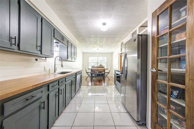 kitchen featuring light hardwood / wood-style flooring, stainless steel appliances, a textured ceiling, and sink