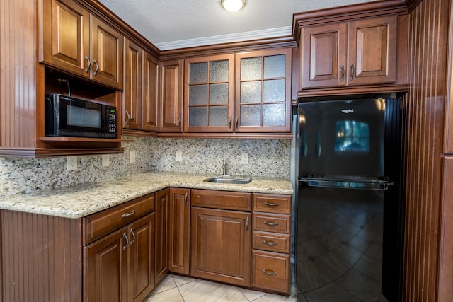 kitchen with light stone countertops, black appliances, sink, a textured ceiling, and light tile patterned floors