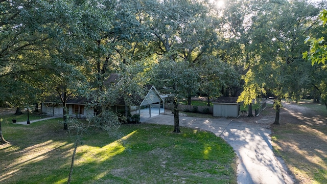 view of front of home with a front yard, a storage shed, and a garage