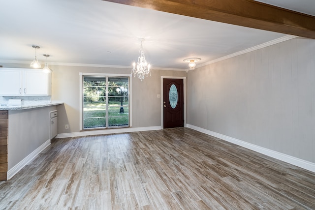 foyer featuring light hardwood / wood-style floors, a notable chandelier, and ornamental molding