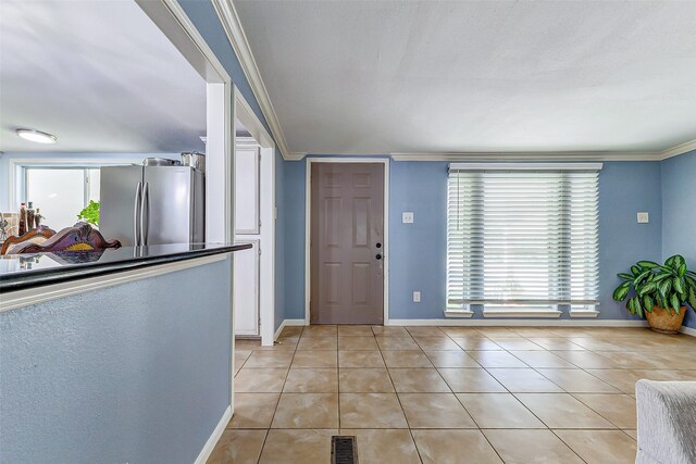 tiled foyer entrance featuring ornamental molding