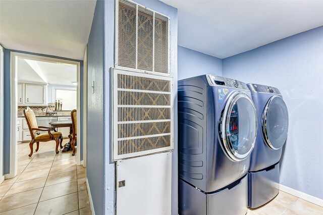 laundry room featuring independent washer and dryer and light tile patterned flooring