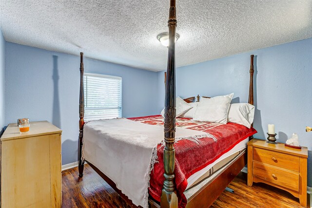 bedroom featuring a textured ceiling and dark wood-type flooring