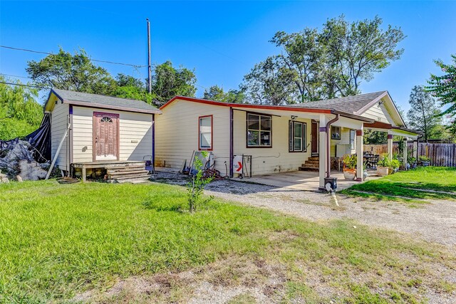 view of front of house featuring a front yard and a shed